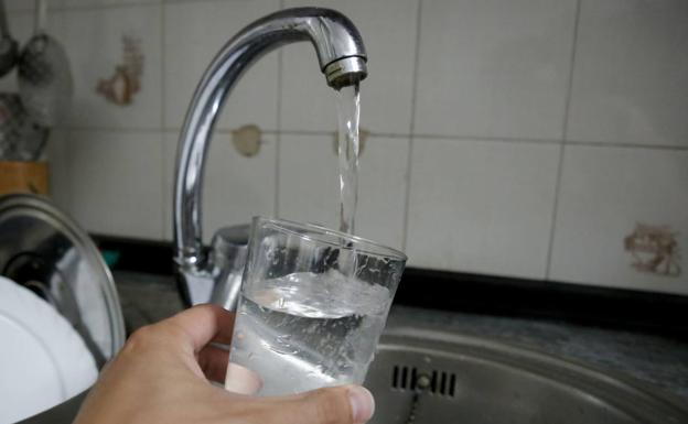 Un ciudadano llena un vaso de agua del grifo de su domicilio en Salamanca. /S. H.